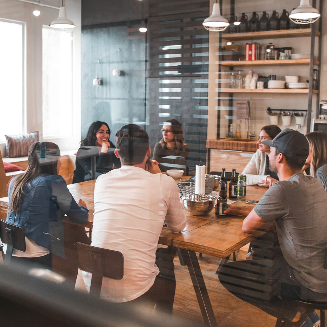 closeup of two people over pages and two open laptops